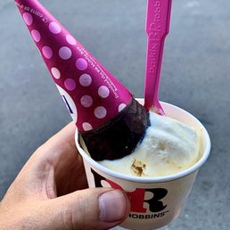 a hand holding a cup of ice cream
