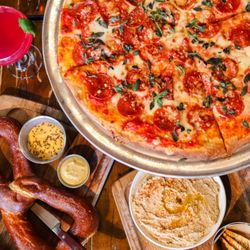 Bowl & Barrel - A delicious pepperoni pizza with a giant pretzel to the side.