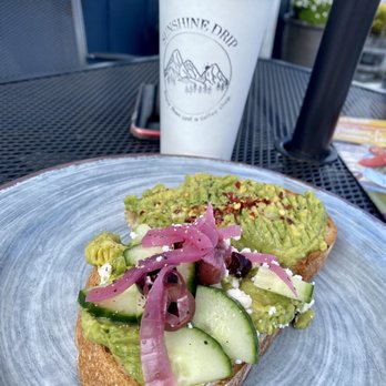 Sunshine Drip - Avo toast halves: Hipster (w red pepper flakes, lime); Greek Mountain (marinated onions, cuces, olives). Bread fresh, crunchy crust. - Breakfast & Brunch Near Me - Coupeville, Washington