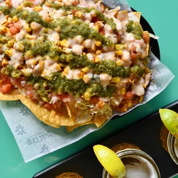 Barrio Tacos Kent - a plate of nachos with salsa and lime wedges - Tacos Near Me - Kent, Ohio
