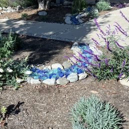Native plants and dry creak with blue landscaping glass Native plants and dry creak with blue landscaping glass