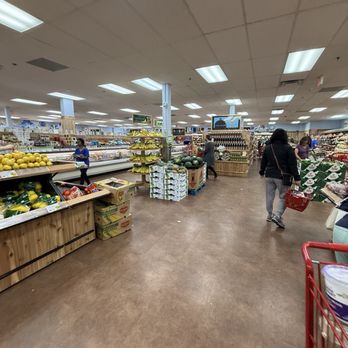 Trader Joe's - Interior of a grocery store showing produce displays, shoppers, and store aisles with bright lighting and ceiling tiles. - Grocery Near Me - Needham, Massachusetts