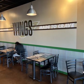 Wingstop - a woman sitting at a table in a restaurant - Chicken Wings Near Me - Boise, Idaho Wingstop - a woman sitting at a table in a restaurant - Chicken Wings Near Me - Boise, Idaho