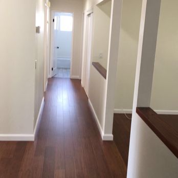 Dream Home Construction - a long hallway with white walls and wood floors - General Contractors Near Me Dream Home Construction - a long hallway with white walls and wood floors - General Contractors Near Me
