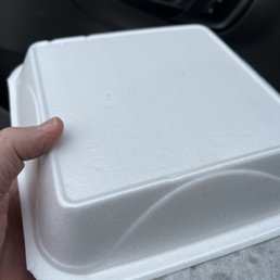 a hand holding a foam container