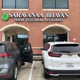 two cars parked in front of a restaurant two cars parked in front of a restaurant