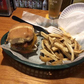 St James Irish Pub - Burger - A burger with a bun, lettuce, tomato, cheese, and bacon, served with a side of French fries and a glass of beer in a bar setting. - Irish Near Me - Fall River, Massachusetts