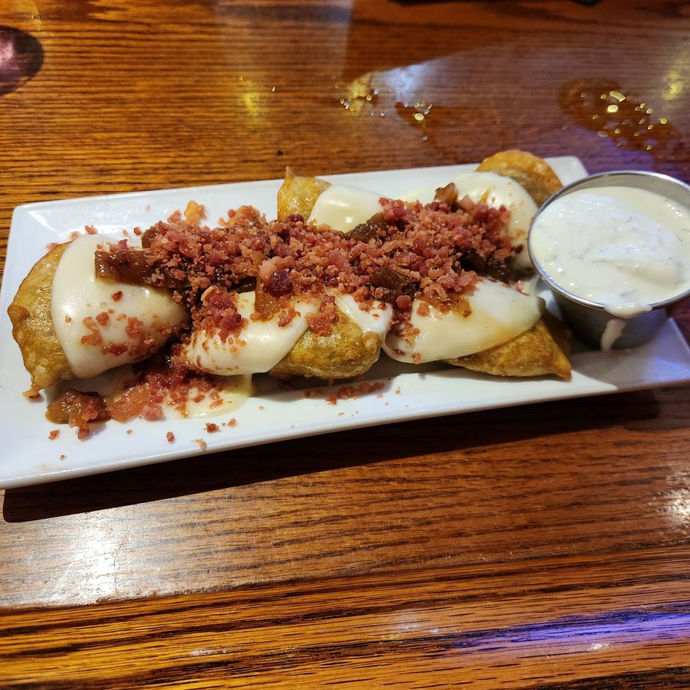 Spinach and Cheese Pierogia with a bacon drizzle and chive sour cream.