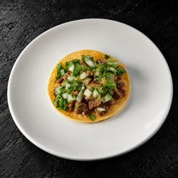 Fuego Cravings - Authentic Mexican street tacos on corn tortillas, topped with onion, cilantro, and guacamole sauce. Choose from six proteins.