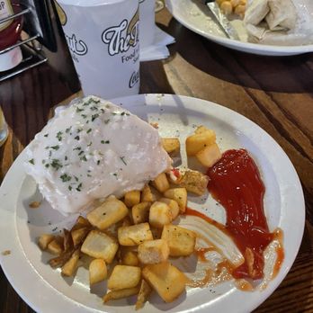 The Peanut - Half of a breakfast burrito and a side of potatoes. - American Near Me - Olathe, Kansas