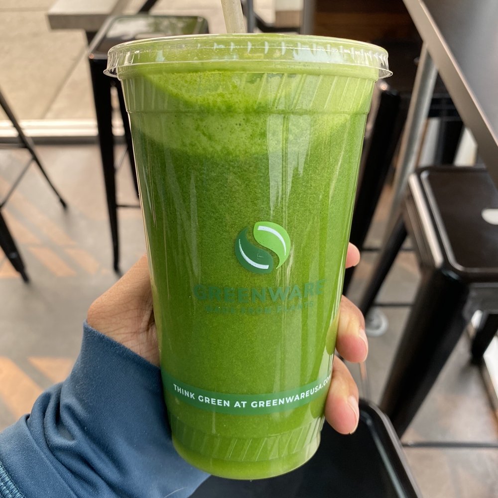 a hand holding a green smoothie