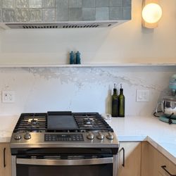 Modern kitchen remodel in San Diego with clean finishes and a beautifully tiled hood detail. Small details make a big difference!