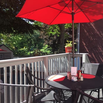 Cafe Reyes - There are a total of five tables with umbrellas outside. Two on the deck, three on the patio below. - Cuban Near Me - Worcester, Massachusetts