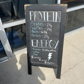 Element Energy - A black chalkboard sign displays protein options and energy-boosting items outside a storefront, with handwritten text and a lightning bolt symbol. - Desserts Near Me - Fort Wayne, Indiana