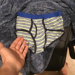a person's hand holding a pair of underwear a person's hand holding a pair of underwear
