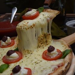 Caprese: Fresh Tomato Sauce, All Natural Mozzarella, All Natural Parmesan, Fresh Tomatoes, Fresh Mozzarella, Olive Pesto, & Fresh Basil.