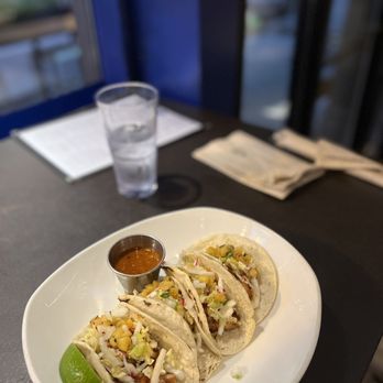 Xoco - three tacos on a white plate with a glass of water - Mexican Near Me - Chicago, Illinois Xoco - three tacos on a white plate with a glass of water - Mexican Near Me - Chicago, Illinois