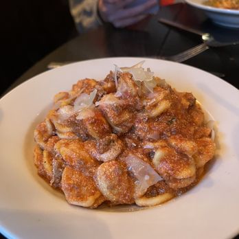 Gabagool Wine Bar - Bolognese - A dish of pasta with meat sauce, topped with cheese shavings, served on a white plate at Gabagool in Fairfield, CT. - Wine Bars Near Me - Fairfield, Connecticut
