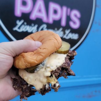 Papi’s Livin Comida Loca - a hand holding a sandwich - Food Trucks Near Me