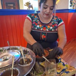 The salsa lady customizing my mild salsa