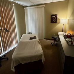 Roots Acupuncture & Wellness - Treatment room with patient and provider chairs and a heat lamp for your feet.