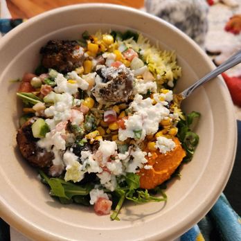 CAVA - So good. Spicy Lamb meatballs bowl. - A Mediterranean greens and grains bowl with falafel, feta cheese, corn, diced vegetables, and greens, served in a disposable bowl. - Salad Near Me - Moorestown, New Jersey