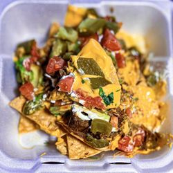 Taqueria Mexico - Nachos with barbacoa and all the toppings - showing a super cheesy nacho on top