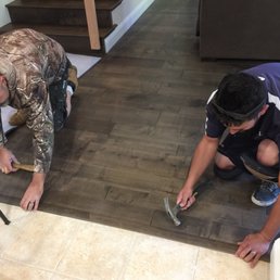two men working on a wood floor