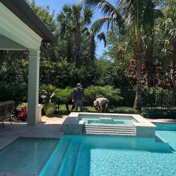 Coastal Best Landscaping - a man standing in a pool - Landscaping Near Me
