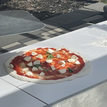 Patulli Pizza Mobile - a pizza being prepared - Caterers Near Me Patulli Pizza Mobile - a pizza being prepared - Caterers Near Me