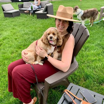 Corked Restaurant & Wine Bar - a woman sitting in a chair with her dog - Wine Bars Near Me - Long Grove, Illinois