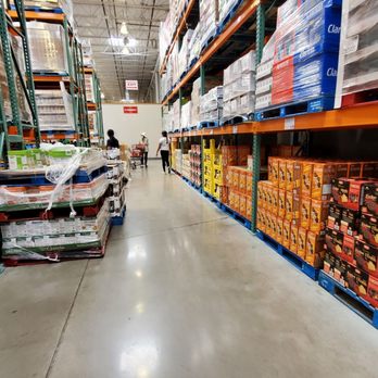 Costco Wholesale - a man walking down the aisle of a store - Tires Near Me - Markham, Ontario