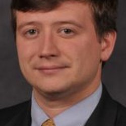 Daniel L. Ellis - Attorney at Law - Photograph of Attorney Daniel L. Ellis. He is wearing a blue shirt, yellow tie, black suit jacket. He has brown hair, brown eyes, white skin