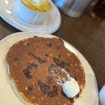 First Watch - Chocolate chip pancake with grits in the  background. - Breakfast & Brunch Near Me - Winter Park, Florida