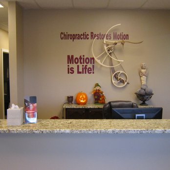 Barrus Chiropractic - Front Desk showing perpetual motion art piece on wall. - Chiropractors Near Me - Pleasant Grove, Utah