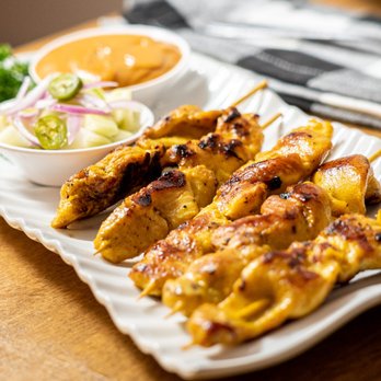 Thai Bistro - grilled chicken skewers on a white plate - Thai Near Me - Santa Barbara, California Thai Bistro - grilled chicken skewers on a white plate - Thai Near Me - Santa Barbara, California