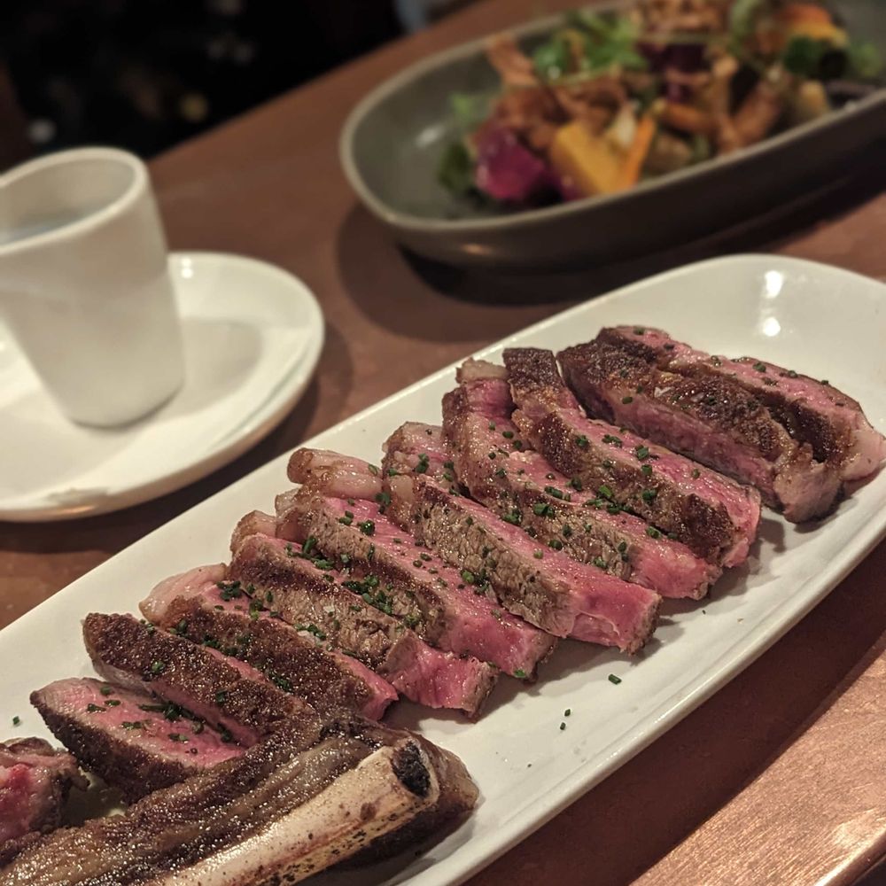 Boeufhaus - Bone-in strip and (background) salad du marché. Underwhelming. - Brasseries Near Me - Chicago, Illinois Boeufhaus - Bone-in strip and (background) salad du marché. Underwhelming. - Brasseries Near Me - Chicago, Illinois