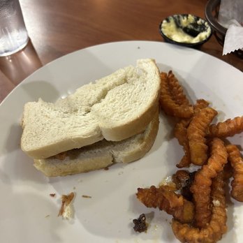 Reno's Roadhouse - a half eaten sandwich and fried onion rings - Steakhouses Near Me - Morehead, Kentucky