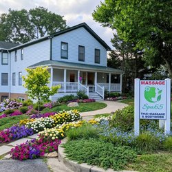 Beautiful storefront of Spa65 Thai Massage & Bodywork, featuring a peaceful walkway and lush garden beds to welcome you.