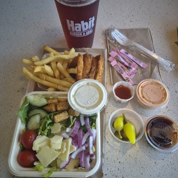 Habit Burger & Grill - My salad, 1/2 fries 1/2 onion rings order, complimentary black tea. Sauces and peppers on the side - Burgers Near Me - Towson, Maryland