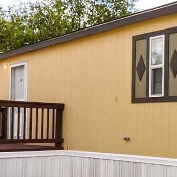 Regency Village - a yellow house with a wooden deck and a tree in the background - Mobile Home Parks Near Me - San Antonio, Texas Regency Village - a yellow house with a wooden deck and a tree in the background - Mobile Home Parks Near Me - San Antonio, Texas