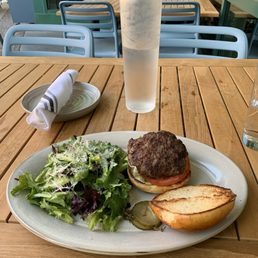 Bison burger and side salad outdoors.