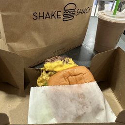 The burger is laying on the cardboard. The burger is laying on the cardboard.