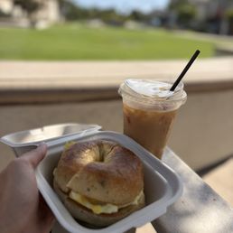 Egg and cheese on rosemary salt bagel, Surf- iced latte