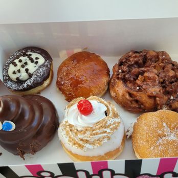 Pinkbox Doughnuts - Top L-R: Holy Cannoli, Blow Torch, Da Apple Fritter Bottom L-R: Pooh, Cherry Bomb, Raspberry Squeeze - Donuts Near Me - St. George, Utah Pinkbox Doughnuts - Top L-R: Holy Cannoli, Blow Torch, Da Apple Fritter Bottom L-R: Pooh, Cherry Bomb, Raspberry Squeeze - Donuts Near Me - St. George, Utah