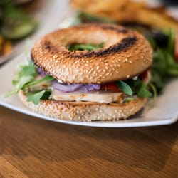 Méli Mellow - Notre bagel poulet est garni de cream cheese, poulet, poivrons grillés marinés, oignons rouges, moutarde et roquette.