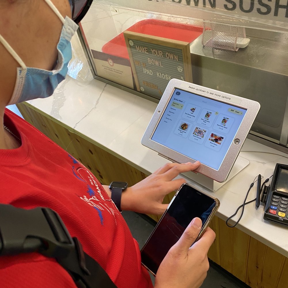 a woman in a face mask using a tablet a woman in a face mask using a tablet