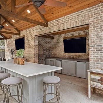 Orion Contractors - an outdoor kitchen with bar stools - General Contractors Near Me