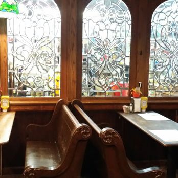 The Station Stop - a row of wooden benches with stained glass windows - American Near Me - Centerville, Indiana