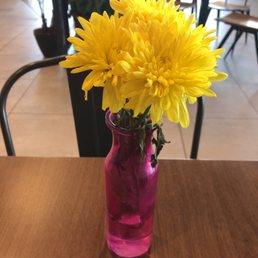 a pink vase with yellow flowers